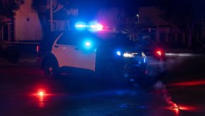 A police SUV with other cars at a crime scene.