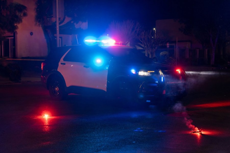 A police SUV with other cars at a crime scene.