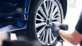 A technician swaps the types of tires on an SUV.