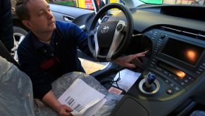 Toyota technician inspects a Prius hybrid recalled for braking issue.