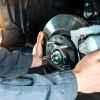 A mechanic putting brake calipers back on a car they're working on