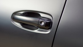 Car door spray-painted flat black in close view of the handle