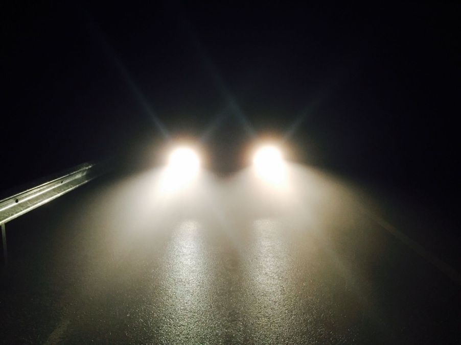 A car's headlights reflecting on the road at night