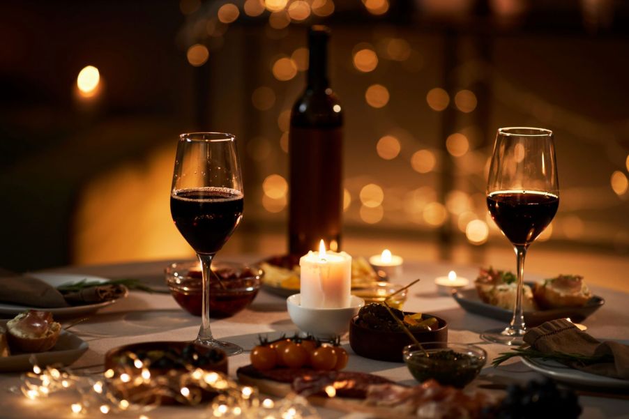 Two glasses of wine on a candlelit table to emulate a date night