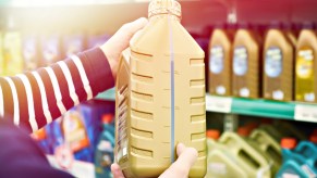 Engine oil on a store shelf with customer holding an option in close side view