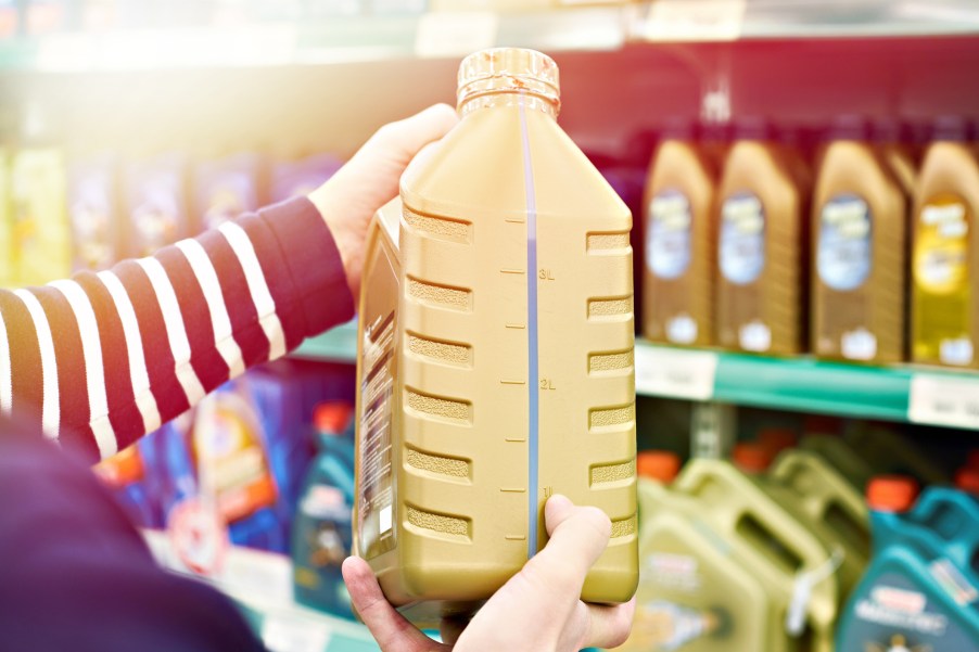 Engine oil on a store shelf with customer holding an option in close side view