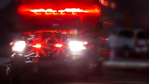 An ambulance at night, driving with its lights on