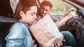 A woman with motion sickness in a car