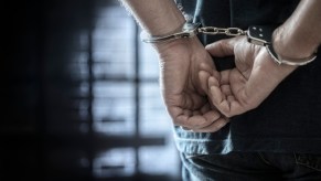 A man in handcuffs in jail