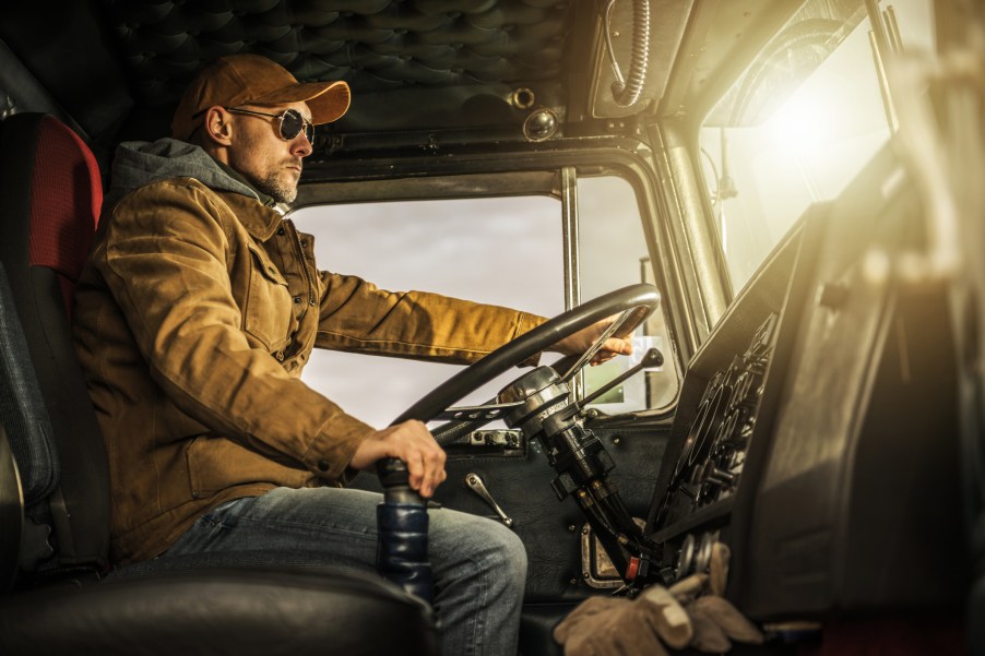 A semi-truck driver in his cab