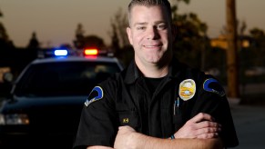 A friendly police officer by his car