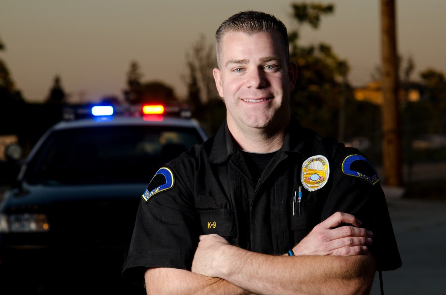 A friendly police officer by his car