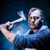 A bloody man holding an ax