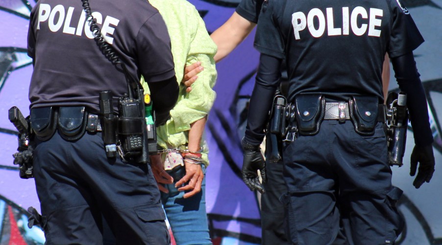 Two police officers arresting a woman