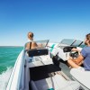 Man driving bowrider boat while woman sits in bow seat