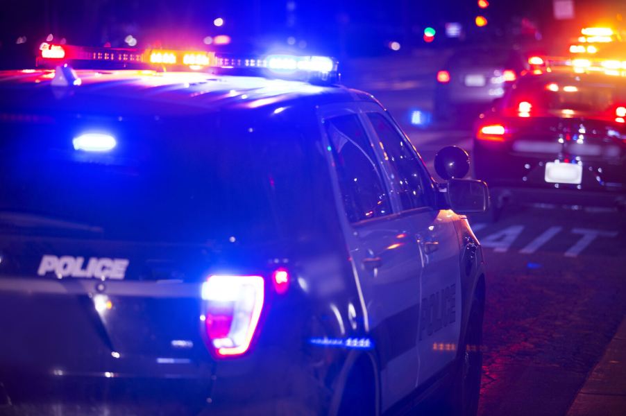 Police cruisers in close view at night with lights on