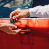 Two men exchanging a car key fob, insinuating the sale of a car