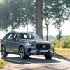 A Volvo XC60 SUV parked on sunny, tree-lined lane