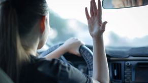 A disgruntled driver gesturing angrily at another driver