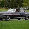 A black and pinstriped 1964 Ford Galaxie, one of the American cars influenced by the Space Race, parked in left angle profile view