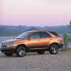 A burnt-orange colored 1998 Lexus RX 300 parked on desert gravel in left front profile view at sunset