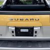 A yellow 2003 Subaru Baja truck's bed in close rear view