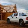 White Ramcharger hybrid pickup truck parked in front of a job site.