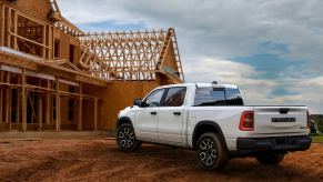 White Ramcharger hybrid pickup truck parked in front of a job site.