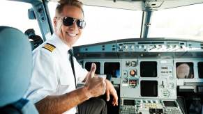 An airline pilot smiles after talking to air traffic control.