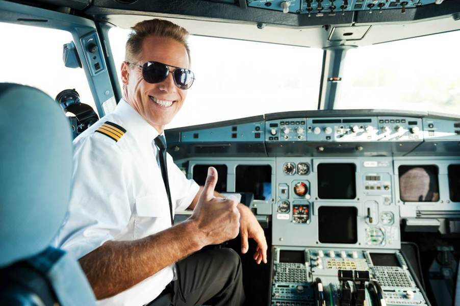 An airline pilot smiles after talking to air traffic control.