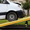 White van being loaded on a rollback with a smashed front after a florida man stole and crashed it.