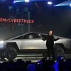 Elon Musk poses with a Tesla Cybertruck after making claims like the Cybertruck can double as a boat for a short period of time.