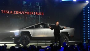 Elon Musk poses with a Tesla Cybertruck after making claims like the Cybertruck can double as a boat for a short period of time.