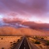 "Haboob" dust storm closing over a desert highway, clouds in the distance.