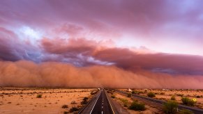 "Haboob" dust storm closing over a desert highway, clouds in the distance.