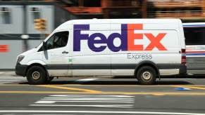 A speeding FedEx van on city streets.