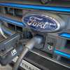 Ford Transit electric EV van grille with a charging cable and the blue logo badge.