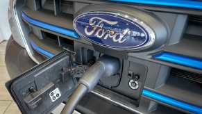 Ford Transit electric EV van grille with a charging cable and the blue logo badge.