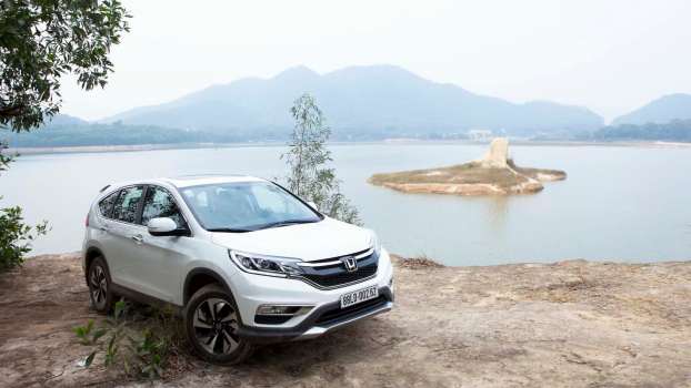 White 2015 Honda CR-V parked in front of a lake.