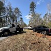 A tow truck pulling trucks out of the mud