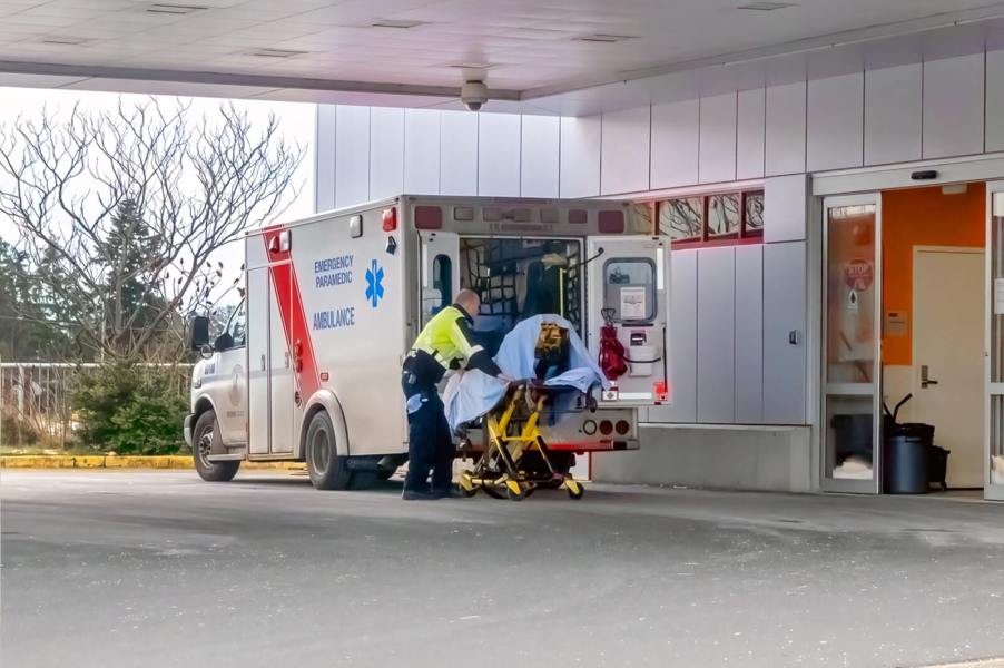 An ambulance parked by the emergency entrance to a hospital.