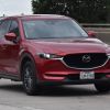 Red Mazda SUV on the highway, trounced the IIHS safety awards for 2025.