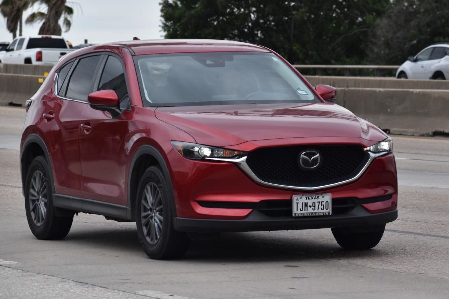 Red Mazda SUV on the highway, trounced the IIHS safety awards for 2025.