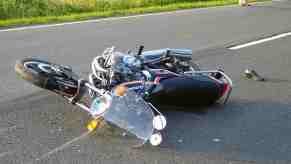 Motorcycle on the pavement after crashing with a train.