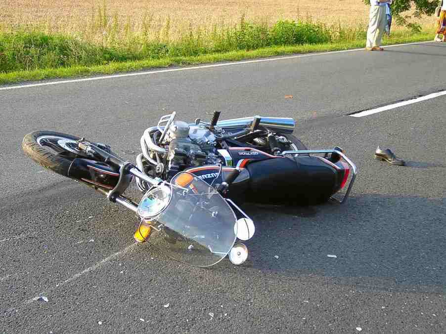 Motorcycle on the pavement after crashing with a train.