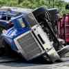 Large semi truck rolled over in the road