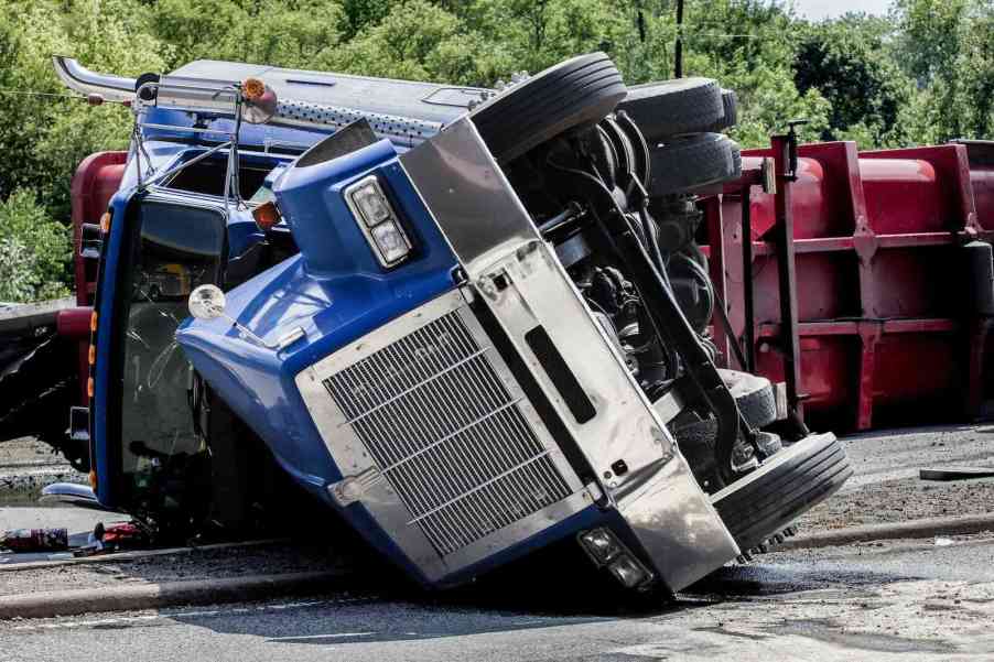 Large semi truck rolled over in the road