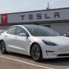 A used Tesla Model 3 parked at a dealer and service center.