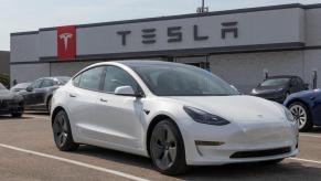 A used Tesla Model 3 parked at a dealer and service center.