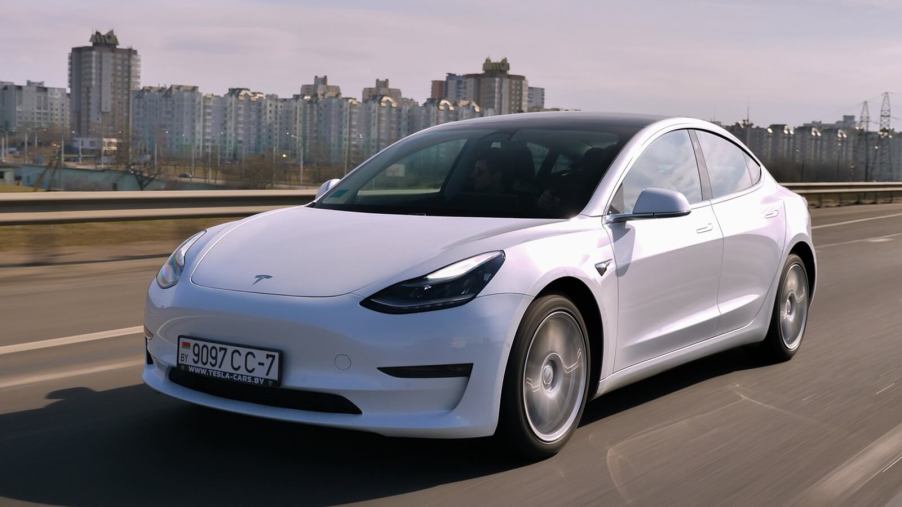 A Tesla Model 3 rolling on a Eastern European highway.